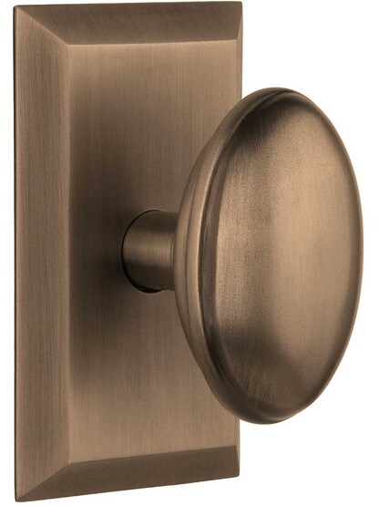 New York Rosette Door Set with Homestead Knobs in Antique Brass.